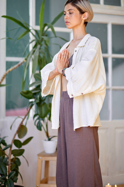 Gorgeous young female holding hands in namaste or prayer, practising yoga and meditating - Valokuva, kuva