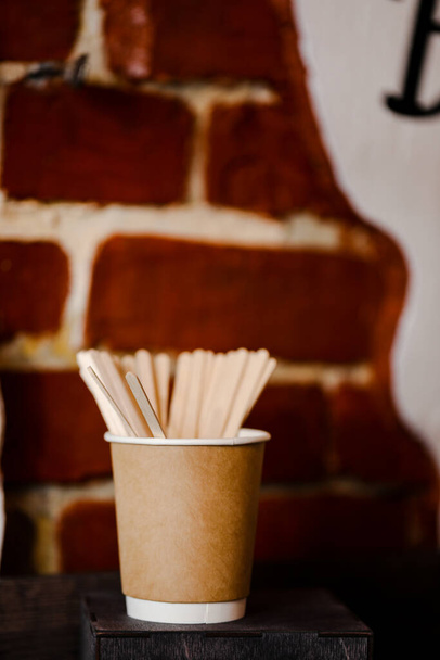 Ξύλινα ξυλάκια στο ενιαίο φλιτζάνι του καφέ σε μια ξύλινη σανίδα - Φωτογραφία, εικόνα