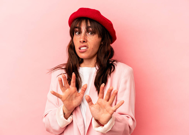 Young Argentinian woman isolated on pink background rejecting someone showing a gesture of disgust. - Foto, Imagem