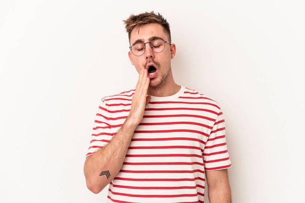 Молодий білий чоловік ізольований на білому тлі позіхання показує втомлений жест, що покриває рот рукою
. - Фото, зображення