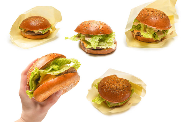 Hamburger in vrouwenhanden geïsoleerd op een witte achtergrond. Bovenaanzicht.  - Foto, afbeelding