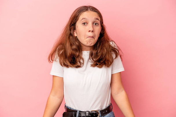 Little caucasian girl isolated on pink background shrugs shoulders and open eyes confused. - Photo, Image
