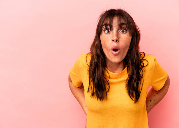 Young Argentinian woman isolated on pink background being shocked because of something she has seen. - Foto, imagen