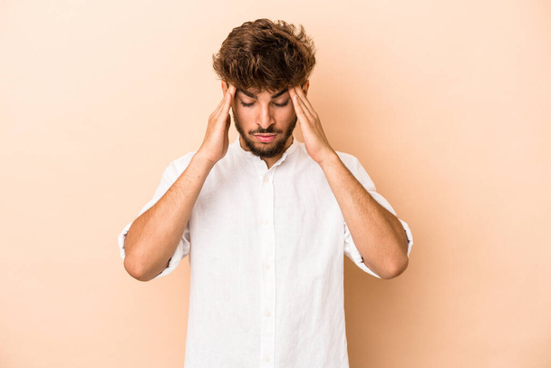 Young arab man isolated on beige background touching temples and having headache. - Photo, image