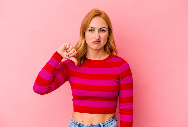 Mulher branca jovem isolado no fundo rosa mostrando polegar para baixo, conceito de decepção. - Foto, Imagem