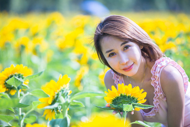 aziatische vrouw bij zonnebloem veld portret outdoor. - Foto, afbeelding