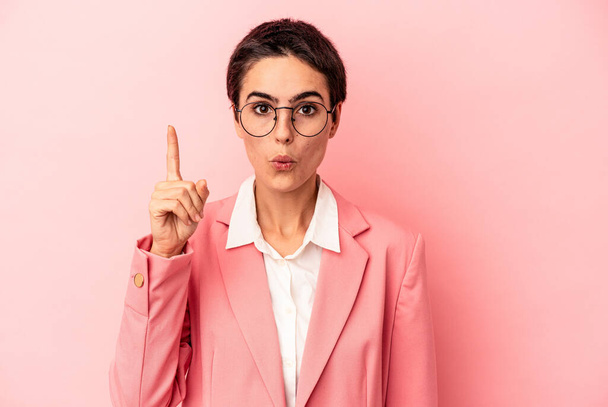 Νεαρή επιχειρηματίας φορώντας ένα ροζ σακάκι απομονώνονται σε ροζ φόντο έχουν κάποια μεγάλη ιδέα, έννοια της δημιουργικότητας. - Φωτογραφία, εικόνα
