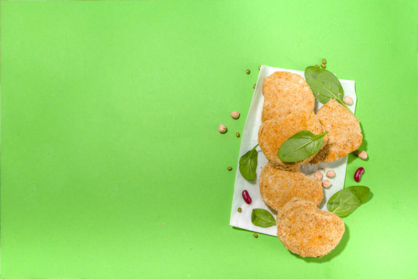 Lab-grown or plant based white meat nuggets over green background - Фото, изображение