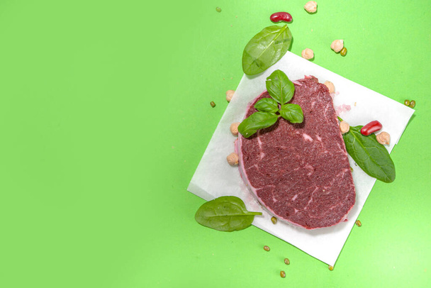 Лабораторные или растительные стейки из красного мяса на зеленом фоне - Фото, изображение