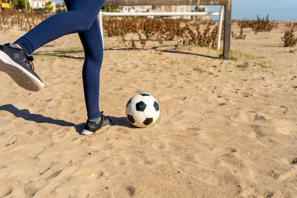 Ноги грають у м'яч на піщаному пляжі. Спортивна концепція
. - Фото, зображення