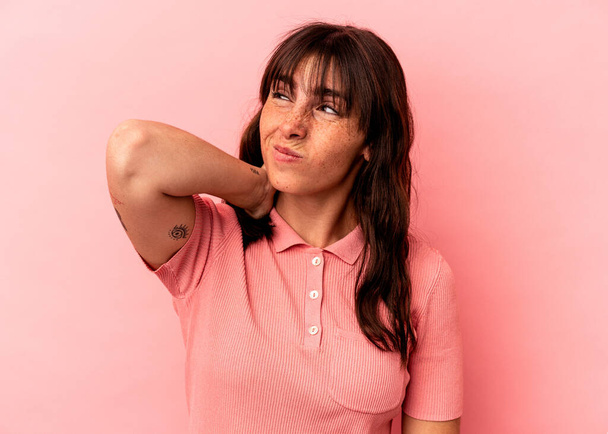 Young Argentinian woman isolated on pink background suffering neck pain due to sedentary lifestyle. - Fotografie, Obrázek