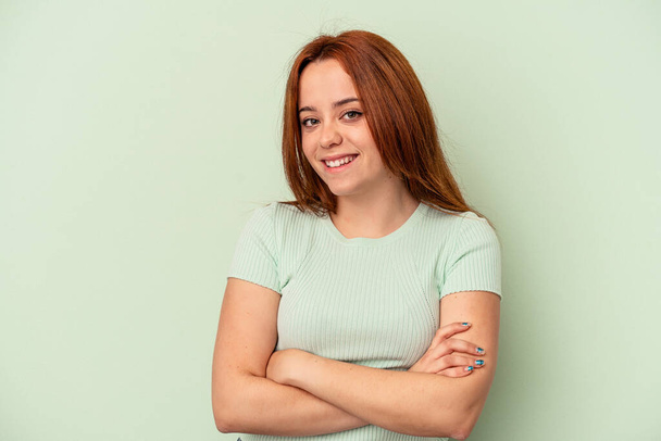 Young caucasian woman isolated on green background happy, smiling and cheerful. - Photo, Image