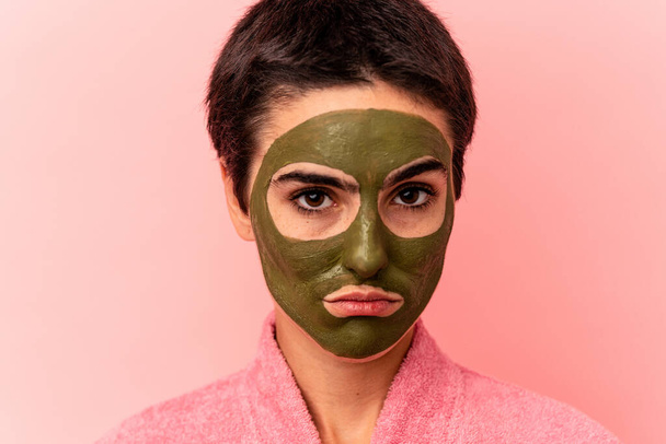 Young caucasian woman wearing a face mask isolated on pink background - Фото, зображення