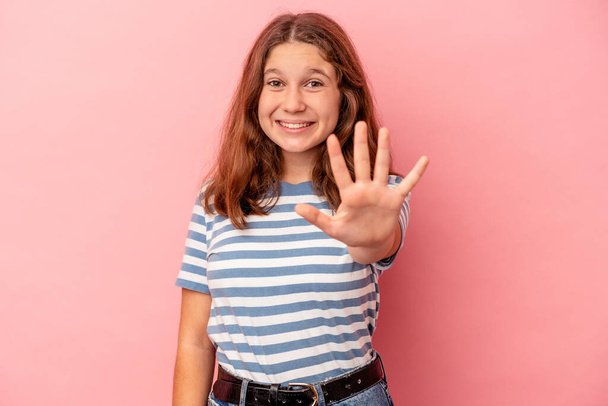 Menina caucasiana pouco isolado no fundo rosa sorrindo alegre mostrando número cinco com os dedos. - Foto, Imagem