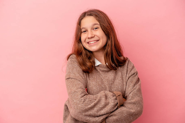 Little caucasian girl isolated on pink background who feels confident, crossing arms with determination. - Photo, Image