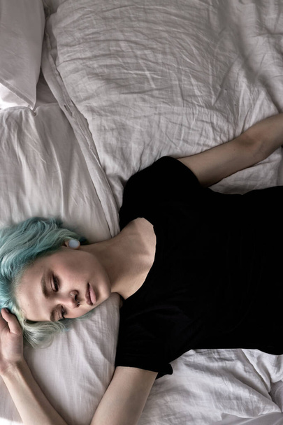 top view on sad female lying on bed, depressed upset woman at home alone - 写真・画像