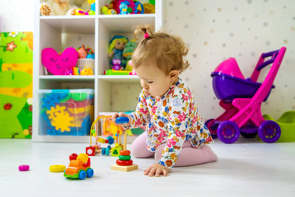 The child plays with toys in the room. Selective focus. Baby. - Photo, Image