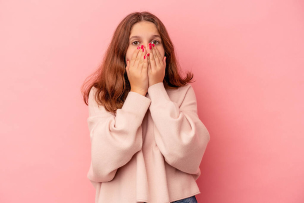 Little caucasian girl isolated on pink background covering mouth with hands looking worried. - Fotoğraf, Görsel