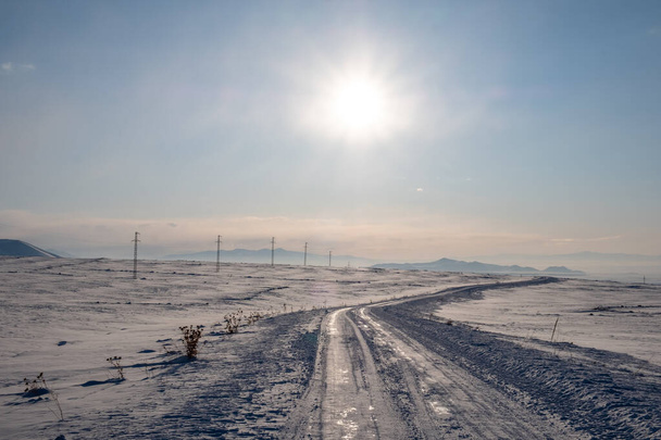 pokryta śniegiem droga w zimowy słoneczny dzień - Zdjęcie, obraz