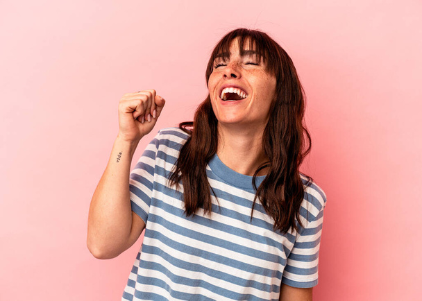 Young Argentinian woman isolated on pink background celebrating a victory, passion and enthusiasm, happy expression. - 写真・画像