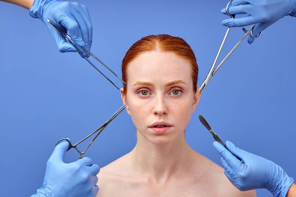 confident woman with red hair looking at camera thinking about surgery process. - Foto, imagen
