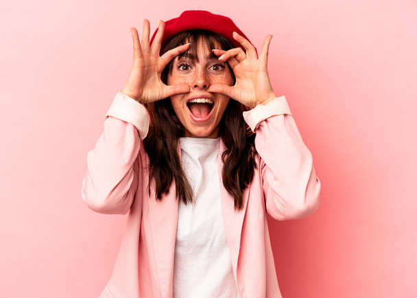 Молода аргентинка, ізольована на рожевому фоні, тримає очі відкритими, щоб мати успіх.. - Фото, зображення