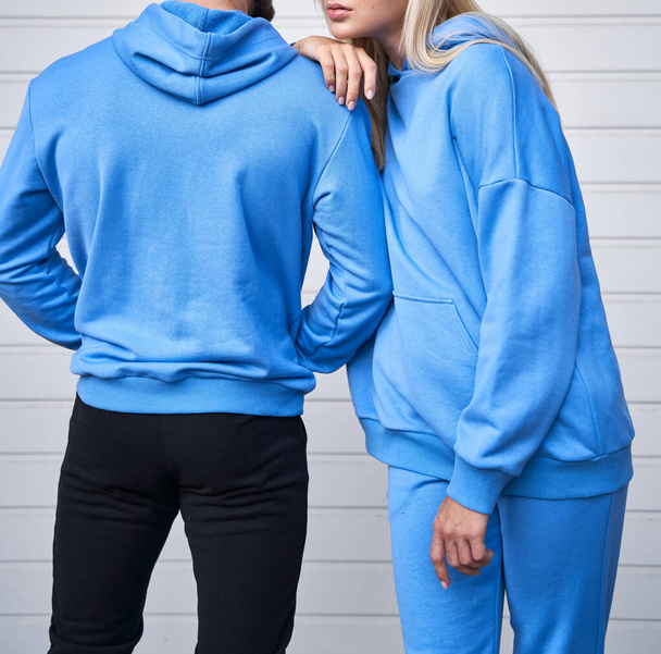 Een vrouw en een man dragen een capuchon zonder logo. Sjabloon voor trui ontwerp. kopieer ruimte streetwear kleding - Foto, afbeelding