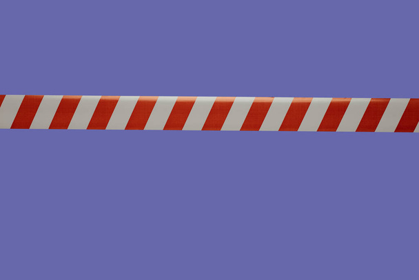 Piros és fehér szalag használják vívás egy lila háttér .barrier szalag behatolás ellen - Fotó, kép