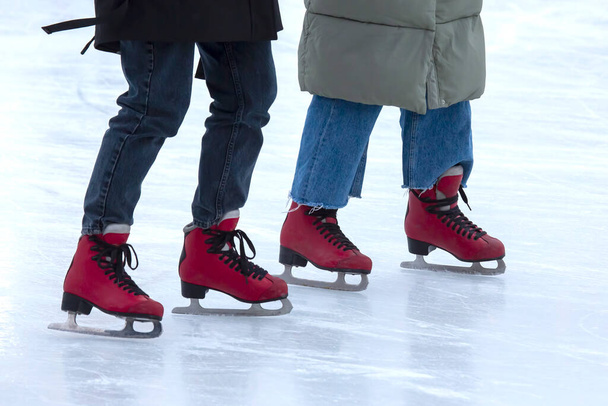 アイスリンクでアイススケート。足はスケートで。冬のアクティブスポーツ&レジャー趣味. - 写真・画像