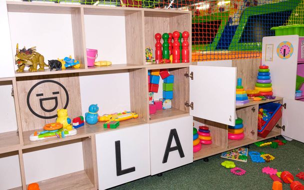 Gabinetes con juguetes en el centro de entretenimiento para niños, juguetes para niños en el rack - Foto, Imagen