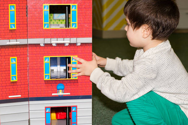 A 4-year-old boy plays in the playroom in the childrens entertainment center with a toy big castle. - Foto, immagini