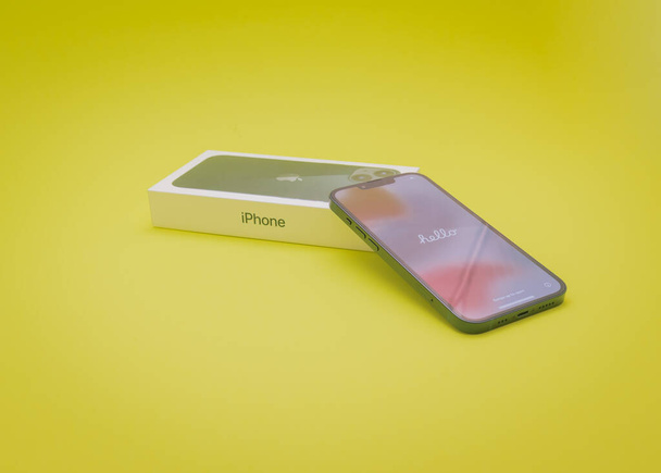 COPPELL, TX, USA-JAN 4, 2022 : Apple box et iPhone 13 avec écran de bienvenue Hello text. Tout nouvel iPhone dans une nouvelle couleur de minuit isolé sur fond jaune. - Photo, image