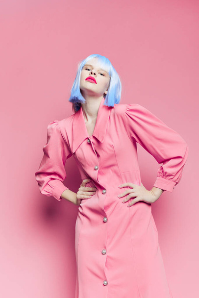 portrait of a woman in blue wig pink dress red lips isolated background - 写真・画像