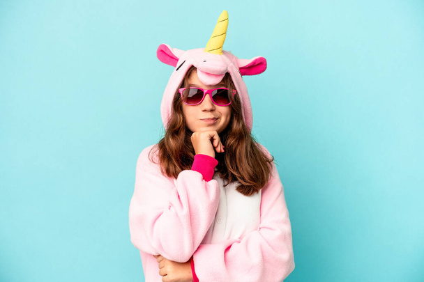 Niña caucásica con un pijama de unicornio aislado sobre fondo rosa - Foto, imagen