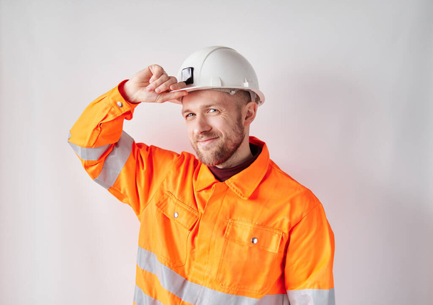 Building contractor in orange vest correcting hardhat - Photo, image