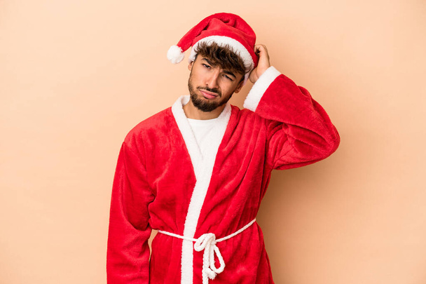 Young arab man disguised as santa claus isolated on beige background being shocked, she has remembered important meeting. - Foto, imagen