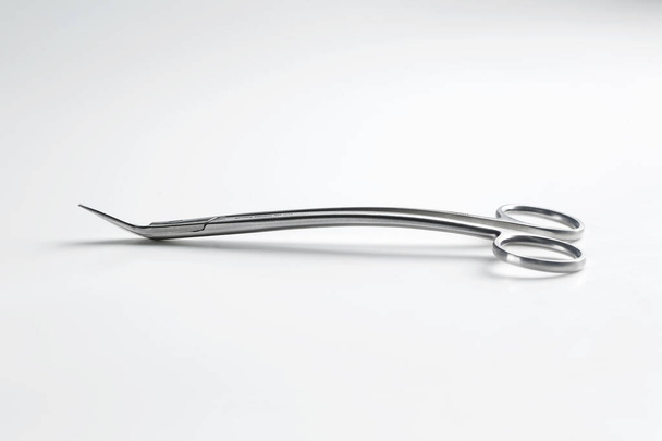 tijeras quirúrgicas de metal duradero para suturar negro sobre un fondo blanco - Foto, Imagen