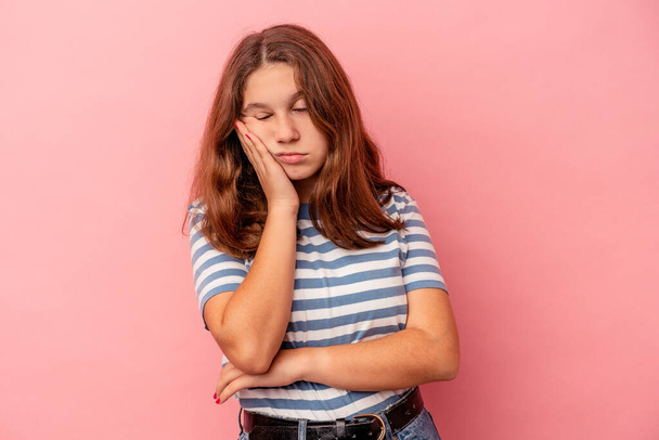 Little caucasian girl isolated on pink background who is bored, fatigued and need a relax day. - Photo, image