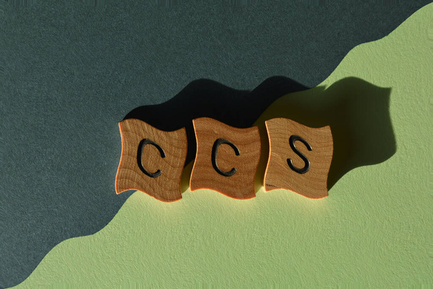 CCS, ακρωνύμιο για την αποθήκευση δέσμευσης άνθρακα, με ξύλινα γράμματα αλφαβήτου που απομονώνονται σε μπλε και πράσινο φόντο - Φωτογραφία, εικόνα