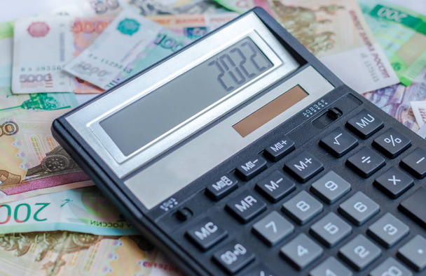 A calculator with the number 2022 and Russian money. The concept of finance, investment, savings and cash. - Photo, image
