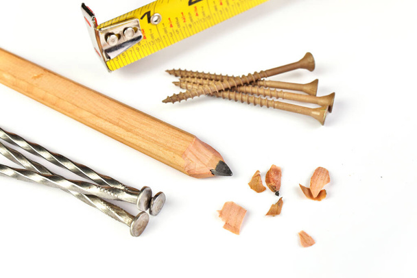 Carpenters Pencil with Sharpening Shavings, Tape Measure, Framing Nails and Deck Screws - Photo, Image