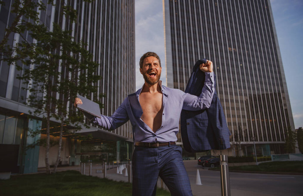 Business man holding laptop standing on the street near business office building. - Foto, Imagem