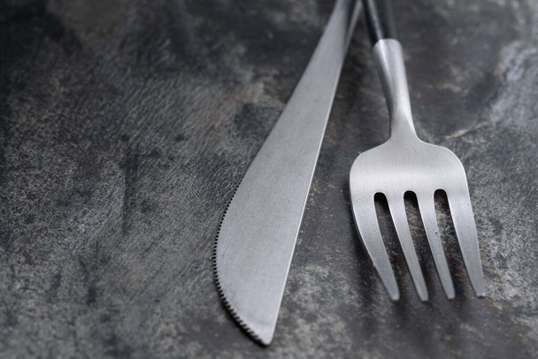 Silver modern cutlery on stone background. Closeup - Photo, Image