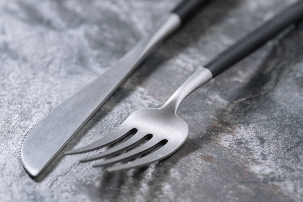 Silver modern cutlery on stone background. Closeup - Fotografie, Obrázek