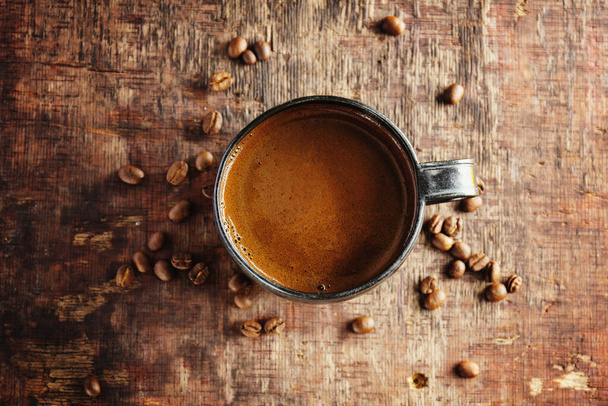 Coffee espresso with coffee beans on old wooden background. Closeup - Foto, afbeelding