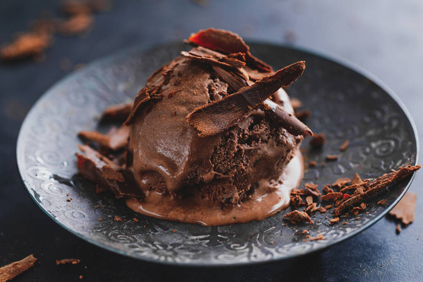 Tasty appetizing chocolate ice cream with chocolate chunks on dark plate on dark background.  - Foto, imagen