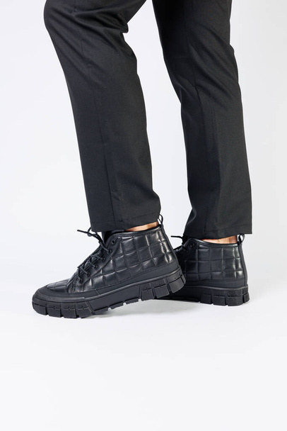 Férfi fekete csizma eredeti bőrből, férfi lábbeli fehér háttérrel. Téli férfi cipő 2022 - Fotó, kép