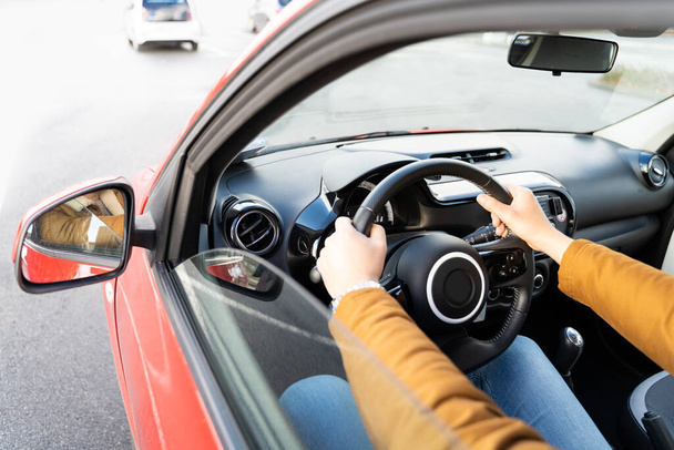 Man casually dressed with hands holding driving wheel riding car at daytime - Photo, image