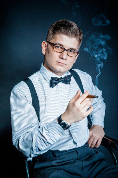 successful young man smoking a cigar - 写真・画像