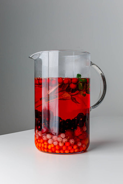 Summer herbal drinks with white currant, sea buckthorn, black currant, cherry, rosemary, mint leaves, Refreshing summer homemade Alcoholic or non-alcoholic cocktails or Detox infused flavored water. - 写真・画像